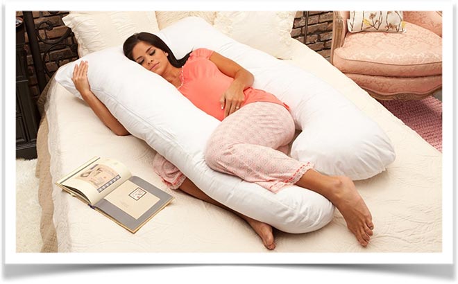 Беременная девушка спит с u образной подушкой