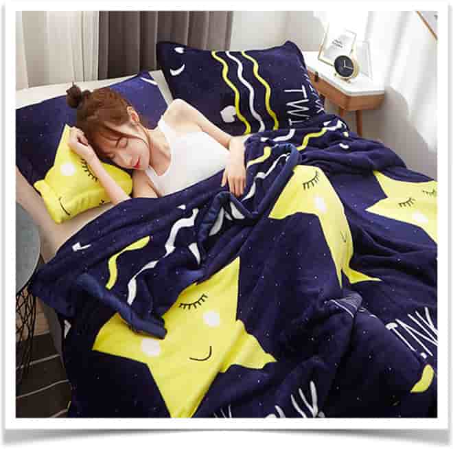 Девушка спит под темно-синем одеялом с желтыми звездами